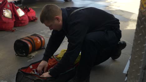 Firefighter-checks-gear-on-a-fire-truck-early-in-the-morning-to-prep-for-emergency-response