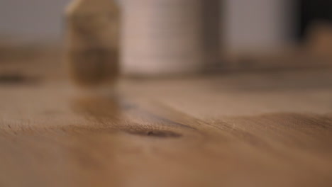 Paintbrush-applying-wood-varnish-back-and-forth-to-DIY-wooden-oak-desk-at-home-close-up