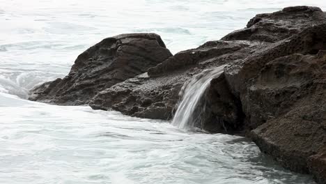 Miniaturwasserfälle,-Die-über-Felsenbecken-Am-Meer-Entstehen,-Wenn-Sie-Von-Den-Rollenden-Wellen-Zerschmettert-Werden
