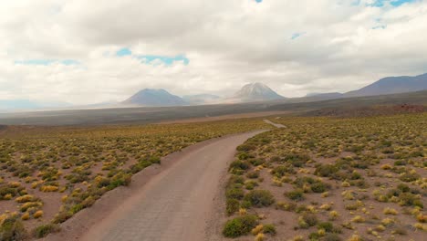 Aerial-cinematic-shot-following-a-dirt-road-in-the-Atacama-Desert,-Chile,-South-America