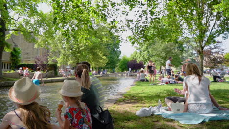 Slow-motion-shot-of-bourton-on-the-water-in-the-busy,-hot-summer-showcasing-the-tourist-hotspot-of-the-cotswolds