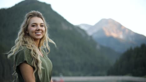 Slow-Motion-Shot-of-a-happy-beautiful-blonde-female-overlooking-a-gorgeous-scene-in-the-mountains