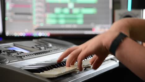 Shot-of-a-musician's-hands-playing-chords-on-a-keyboard-in-a-home-recording-studio