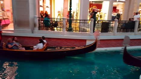 Gimbal-shot-of-Venetian-Gondolas-with-tourists-at-the-Venetian-in-Las-Vegas,-Nevada,-United-States