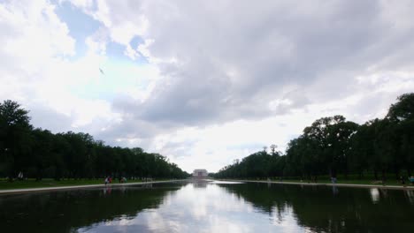 Slow-tilt-down-to-the-water-to-the-front-steps-of-the-Lincoln-Memorial-taken-from-the-reflection-pond-with-people-in-the-foreground