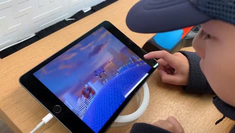 Small-hands-playing-with-the-Hot-Wheels-id-Smart-Track-Kit-at-an-Apple-store