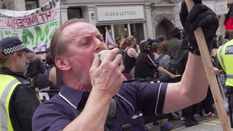 An-Antifa-leader-screams-through-a-microphone-in-London,-UK