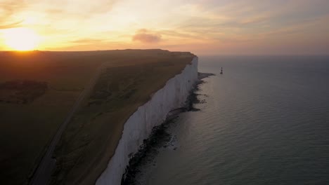 Aerial-view-of-Beachy-Head-Lighthouse-and-white-cliffs-at-sunrise-Eastbourne-,-United-Kingdom