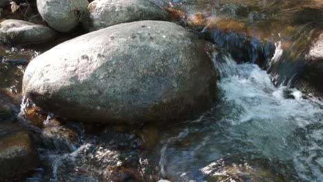 A-very-close-shot-of-a-river,s-surface-plenty-of-rocks-following-the-stream