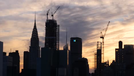 Einspielung-Des-Chrysler-Building,-Des-Metlife-Building-Und-Des-Baus-Neuer-Wolkenkratzer-Bei-Sonnenuntergang,-Während-Im-Hintergrund-Ein-Helikopter-In-New-York-City-Vorbeifliegt