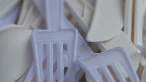 Close-up-pan-over-a-bunch-of-single-use-plastic-utensils