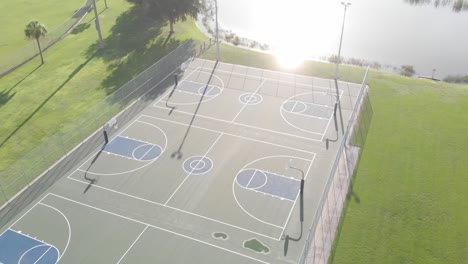 Super-smooth-drone-flight-turning-over-3-perfectly-painted-public-blue-basketball-courts
