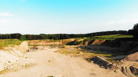 Aerial-dolly-shot-of-dunes,-pits-and-pond-in-a-quarry-