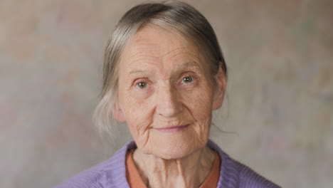 Close-up-portrait-of-a-happy-elderly-senior-woman-looking-at-camera-and-smiling