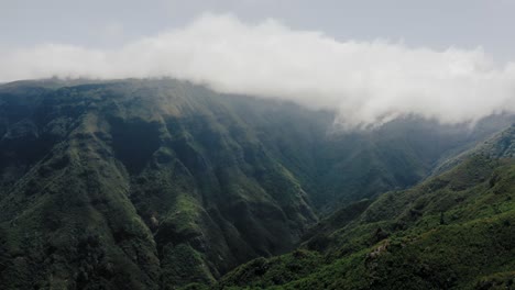 Aerial-video-footage-of-tropical-rainforest-on-Madeira-with-moving-clouds-and-lush-vegetation,-side-movement