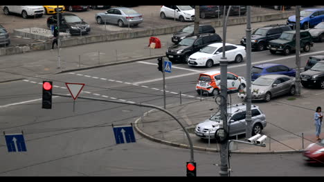 Busy-intersection-in-an-urban-city-with-a-lot-of-cars-parked-on-a-red-light-and-others-crossing-the-road-on-a-green-light