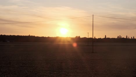 Aufnahme-Von-Feldern-Im-Vordergrund-Bei-Einbruch-Der-Nacht-Vor-Dem-Hintergrund-Eines-Orangefarbenen-Sonnenuntergangs-In-Der-Normandie-Frankreich