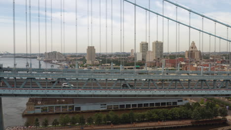 Close-up-aerial-view-of-Philadelphia-Ben-Franklin-Bridge-and-river-in-the-summer-with-cars-and-traffic-driving-on-the-road-into-the-city