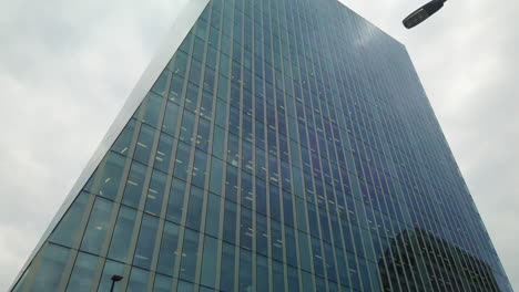 Camera-Tilt-of-Green---Blue-Glass-Office-Block-in-daytime-London-with-traffic