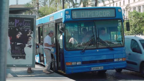 Senior-citizens-get-on-blue-city-bus-in-Jerez,-Spain,-Slow-Motion