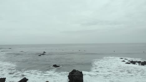 Aerial-Dolly-to-the-right-along-the-waves-on-a-cloudy-day-at-Pichilemu,-Chile-4K