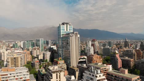 Fliegen-über-Die-Stadt,-Die-An-Einem-Sonnigen-Tag-Einen-Wolkenkratzer-Schließt,-Santiago-Chile-4k