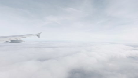 Vista-Desde-La-Ventana-De-Un-Avión-Sobre-El-Reino-Unido-En-Cámara-Lenta-Durante-Un-Día-Nublado