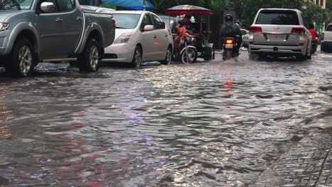Tuk-Tuk-Sprüht-Wasser,-Während-Es-Durch-überflutete-Straßen-Fährt