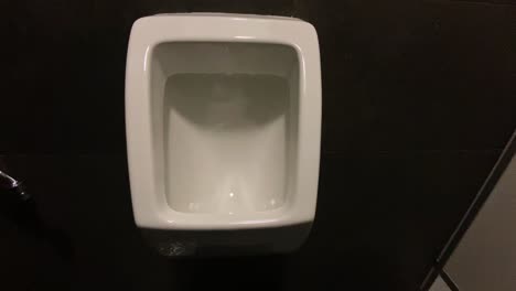 Die-Frontansicht-Des-Urinals,-Das-Freistehende-Urinal-Hängt-An-Der-Wand-Eines-Modernen-Badezimmers,-Kippvideoaufnahme