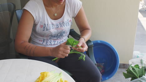 Woman-prepares-zucchini-flowers-for-traditional-kalamata-food-outdoors