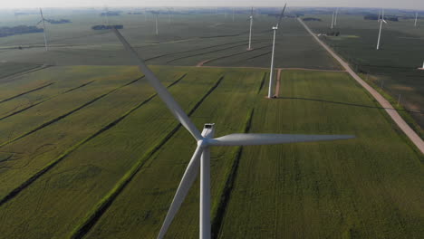 Aerial-video-lowering-down-on-a-wind-generating-spinning-on-a-hot-summer-day-in-the-midwest