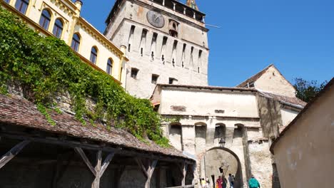 Tilt-up-shot-of-the-clock-tower-in-Sighisoara,-Romania,-from-Strada-Turnului-with-the-covered-wooden-stairs