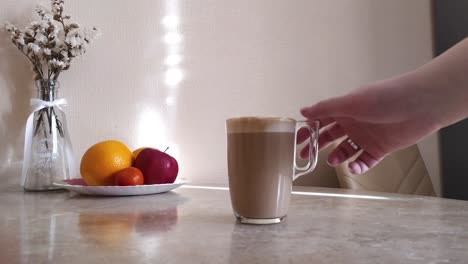 Die-Hand-Der-Frau-Nimmt-Eine-Tasse-Heißen-Kaffee-Mit-Milch-Weg
