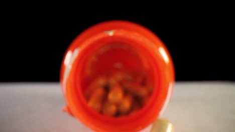moving-past-cap,-slowly-pushing-into-an-orange-supplement-pill-bottle