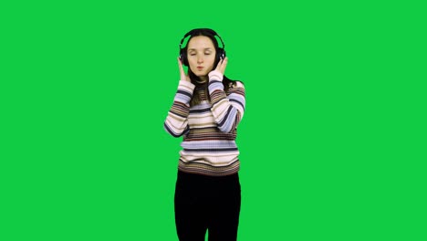 Fröhliches-Gir-Mit-Kopfhörern-Tanzt-Vor-Dem-Grünen-Bildschirm