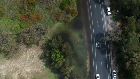 Luftaufnahmen-Von-Der-Polizei,-Die-Nach-Einem-Kürzlichen-Regenguss-An-Der-Goldküste-Australiens-Den-Verkehr-Von-Einer-überfluteten-Straße-Wegleitet