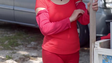 Mujer-Vestida-De-Rojo,-Posando-Para-La-Fotografía-Con-Un-Elaborado-Sombrero-Decorativo