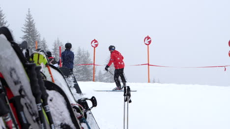 Skifahrer-Skifahren-Bei-Schneefall,-Ski-Und-Snowboard-Im-Vordergrund