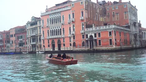 Water-taxi-boat-in-Venetian-Canal-on-grey,-cloudy-day
