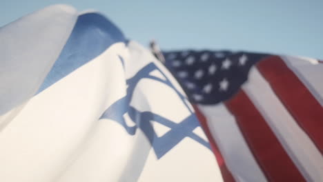 Israel-and-American-Flags-Flying-Together,-Slow-Motion-Close-Up-in-a-Blue-Sky