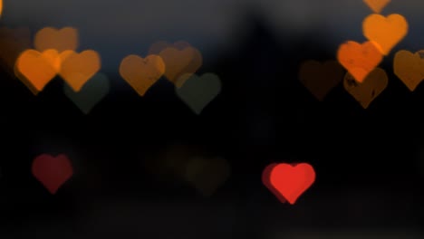 Beautiful-hearts-bokeh-from-moving-car-and-traffic-lights-at-the-evening,-Valentines-Day,-wedding-day-or-social-media-Like-background-concept