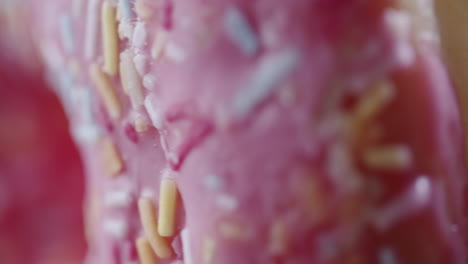 Extreme-Makroaufnahme-Eines-Rosafarbenen-Donuts,-Der-Sich-Vertikal-Dreht