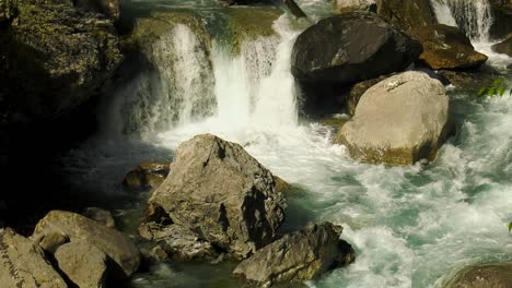 Rushing-water-in-mountain-stream-cascading-over-boulders,-Pyrenees