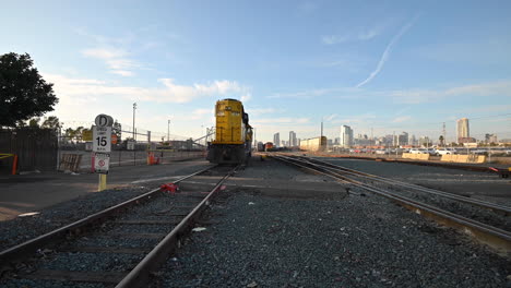 Un-Tren-Amarillo-Se-Detiene-Por-Un-Tiempo-Entre-Los-Ferrocarriles-En-San-Diego,-California,-Ee.uu.