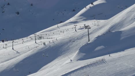 Slow-motion-of-the-ski-resort-Pas-de-la-Casa,-with-skiers-and-lifts