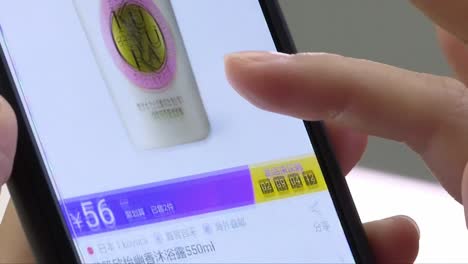Close-up-shot-of-female-person-shopping-online-with-smartphone-in-chinese-online-shop