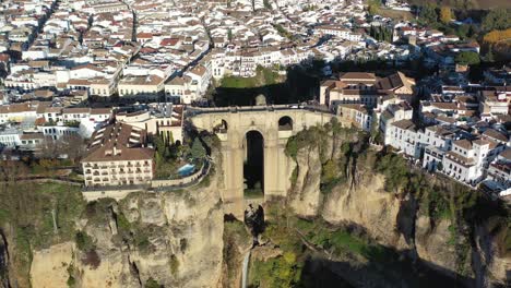 Village-of-Ronda-Spain-with-Puente-Nuevo-arch-bridge-part-of-the-Málaga-Andalucia-province,-Aerial-pan-right-circling-shot