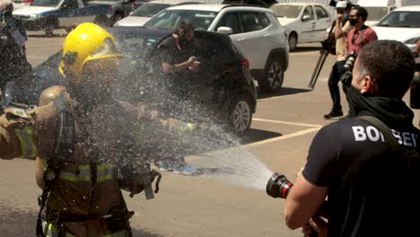 Firefighter-is-sprayed-down-with-a-hose-to-clean-equipment-from-virus-and-chemical-contamination-after-responding-to-a-COVID-19-hospital-fire