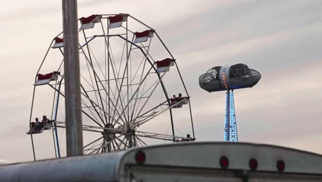 Satellite-ride-and-ferris-wheel-over-food-cart-roof-at-carnival