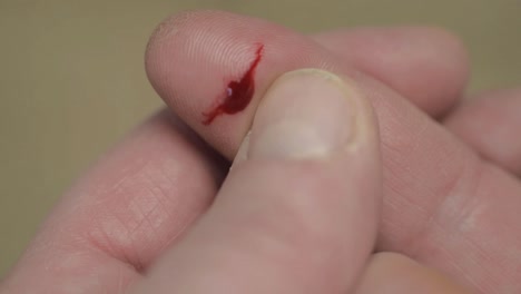 Paper-cut-on-finger-with-drop-of-blood-close-up